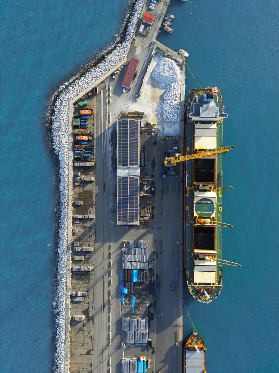 Vista aérea de porto com navio de carga e terminal logístico