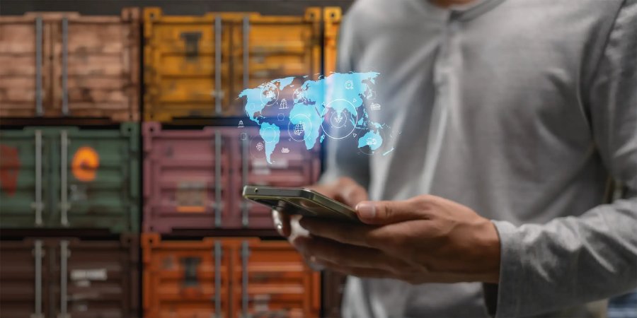 Executivo com smartphone diante de contêineres de carga e rede logística global